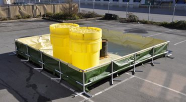 Frame berm holding yellow overpack drums