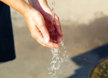 Clean water pouring into cupped hands